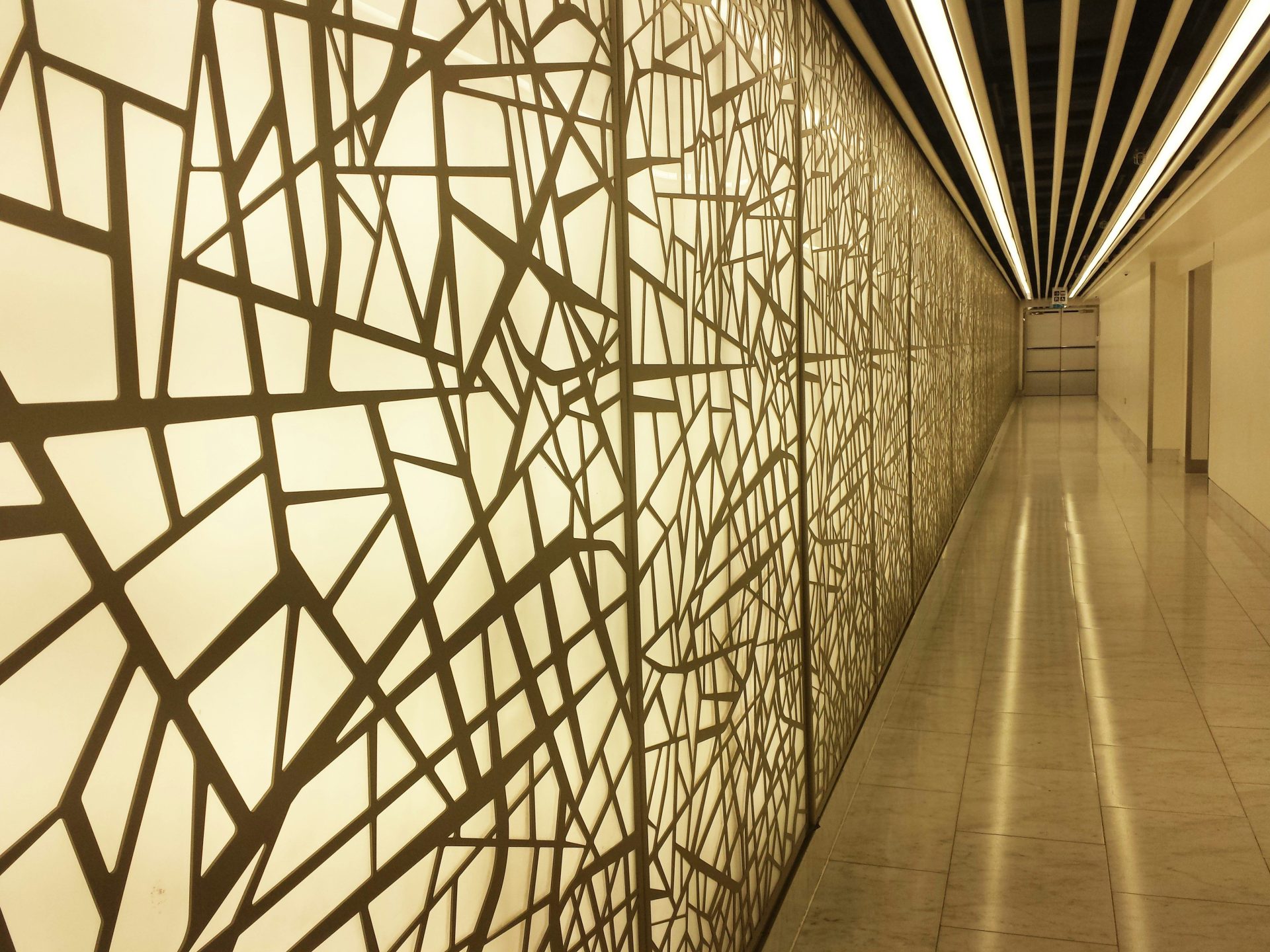 a long hallway with a decorative wall covering it