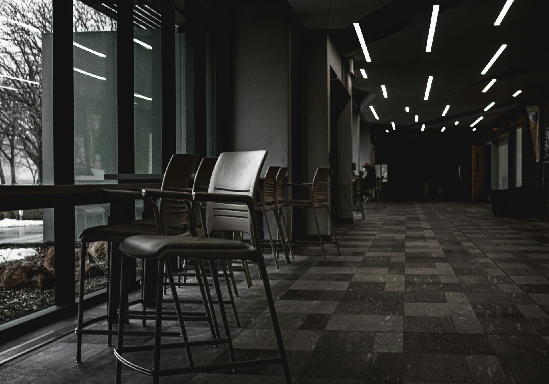 Chairs sit near a window in a dark interior.